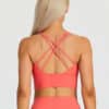 Model wearing fiiT Pixie sports bra in Coral